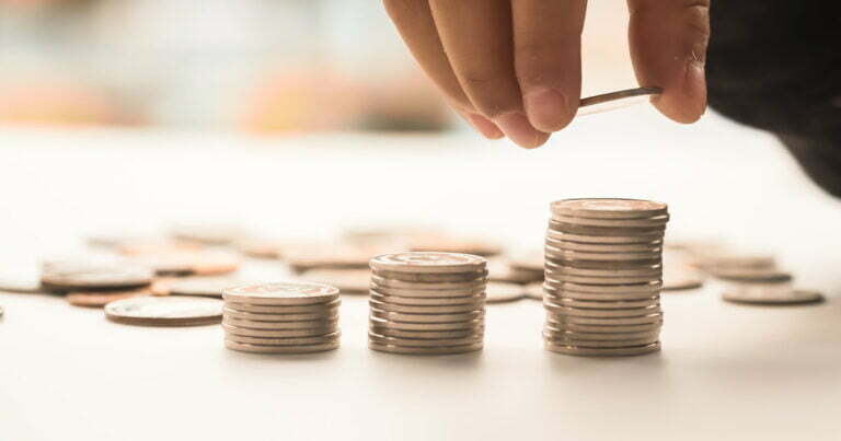 person stacking coins in towers