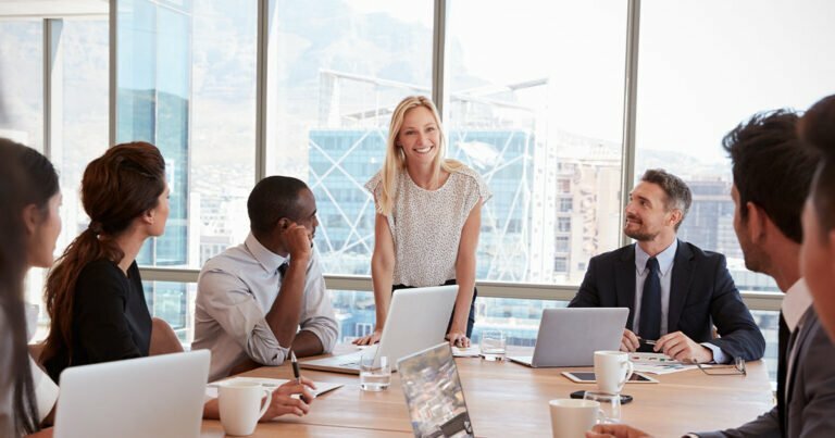 Happy business lady in board meeting with coworkers