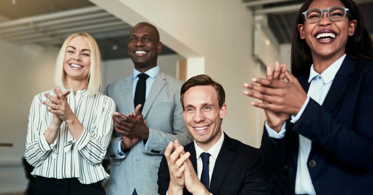 Happy business people clapping