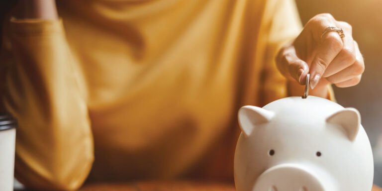 lady putting a coin into a piggy bank