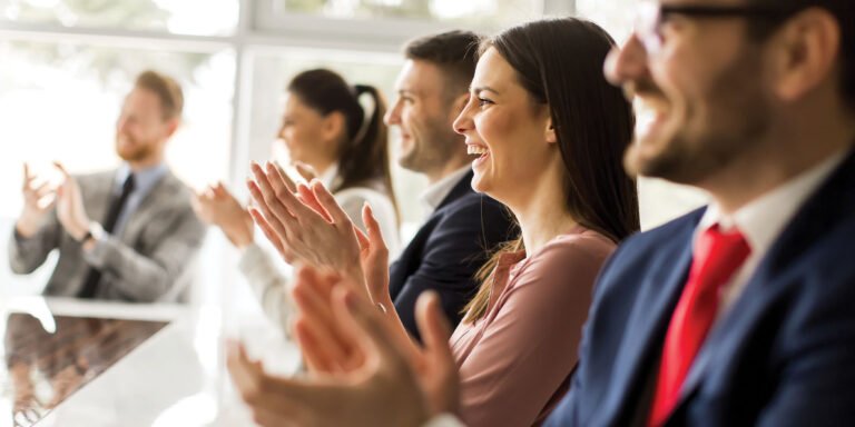Happy business people clapping