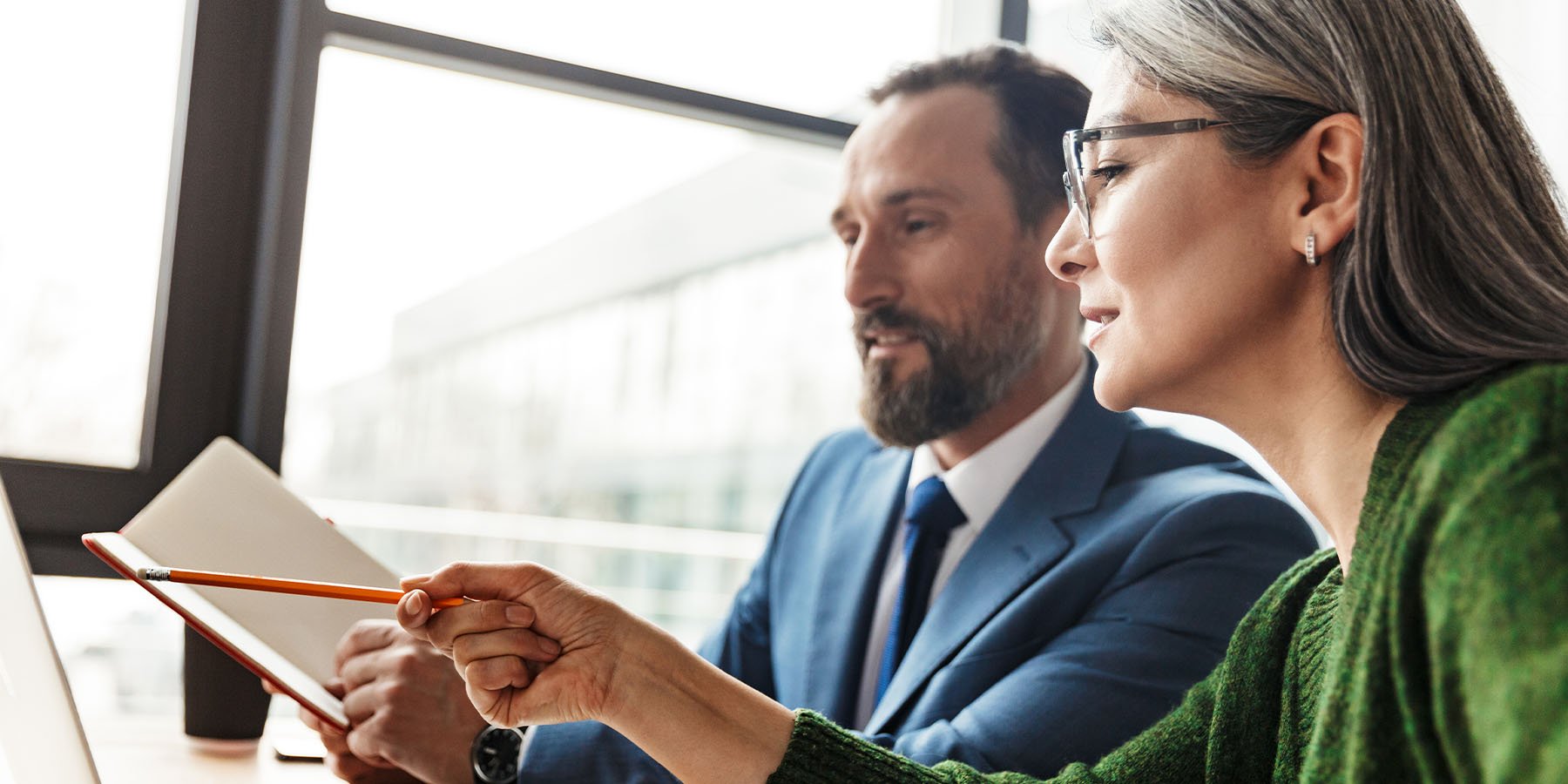 Lady Coworker helping her male coworker understand something written down