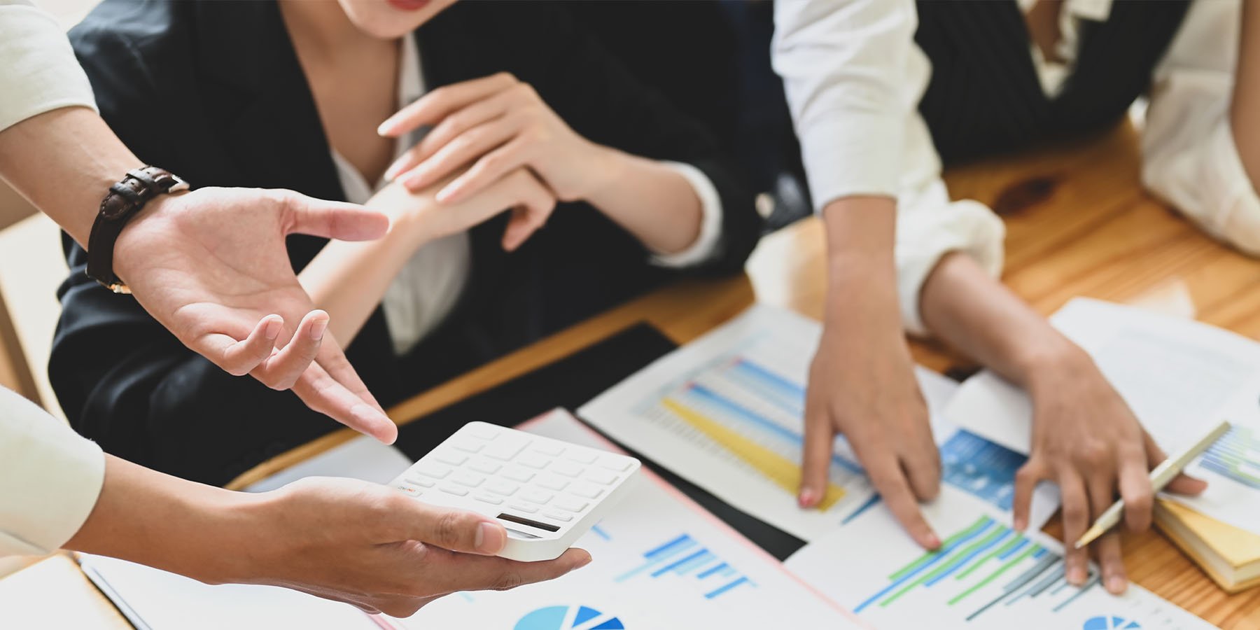 Group of workers at desk with business papers all over