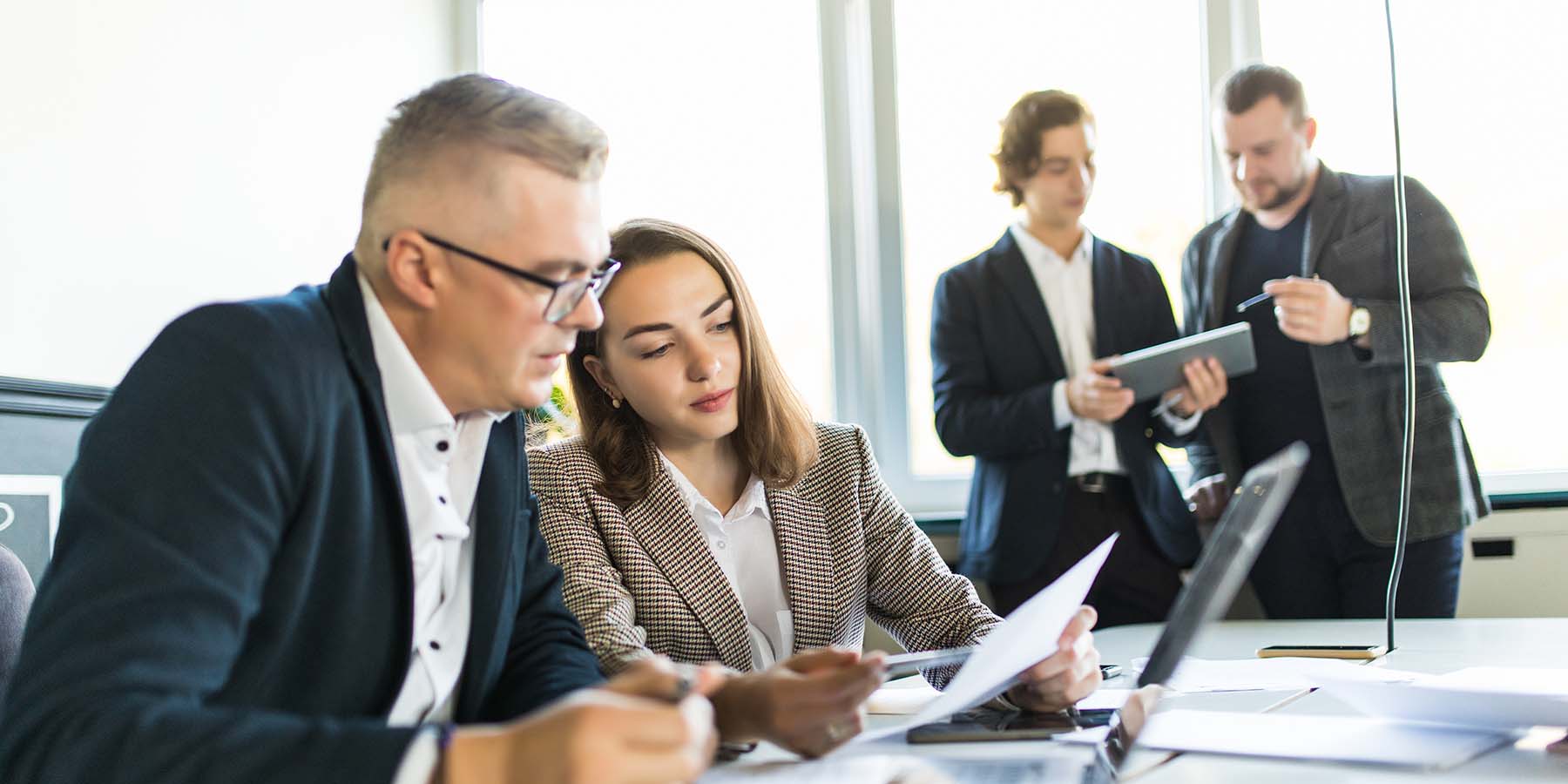 Business people sitting at table looking over paperwork