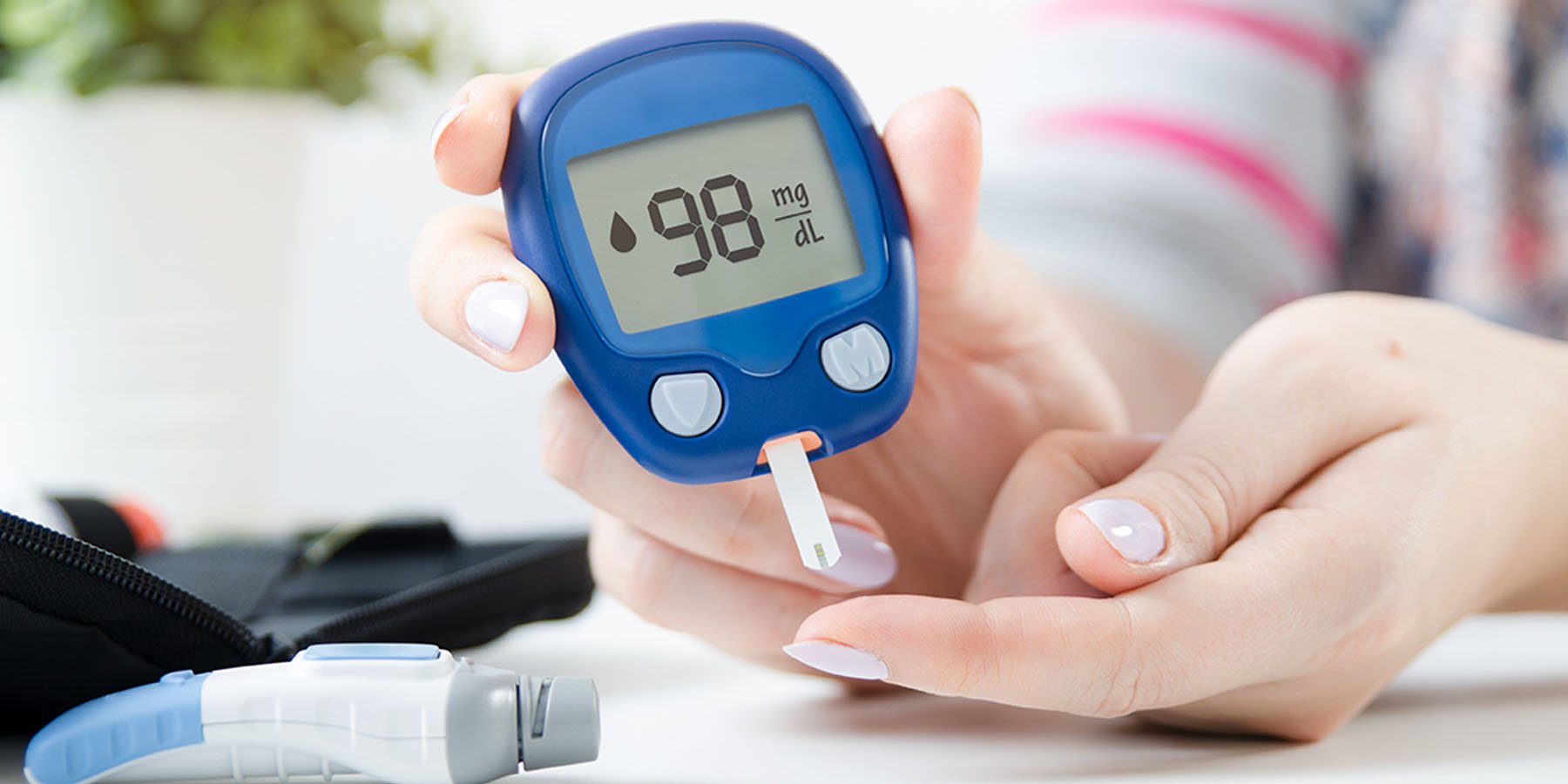 Lady taking her blood sugar reading with a testing device