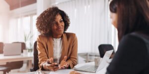 Business woman at table explaining things to coworker