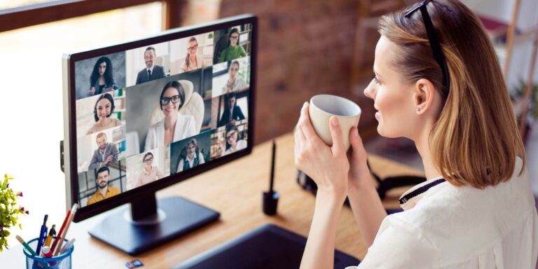 Lady drinking coffee while on an online meeting with coworkers