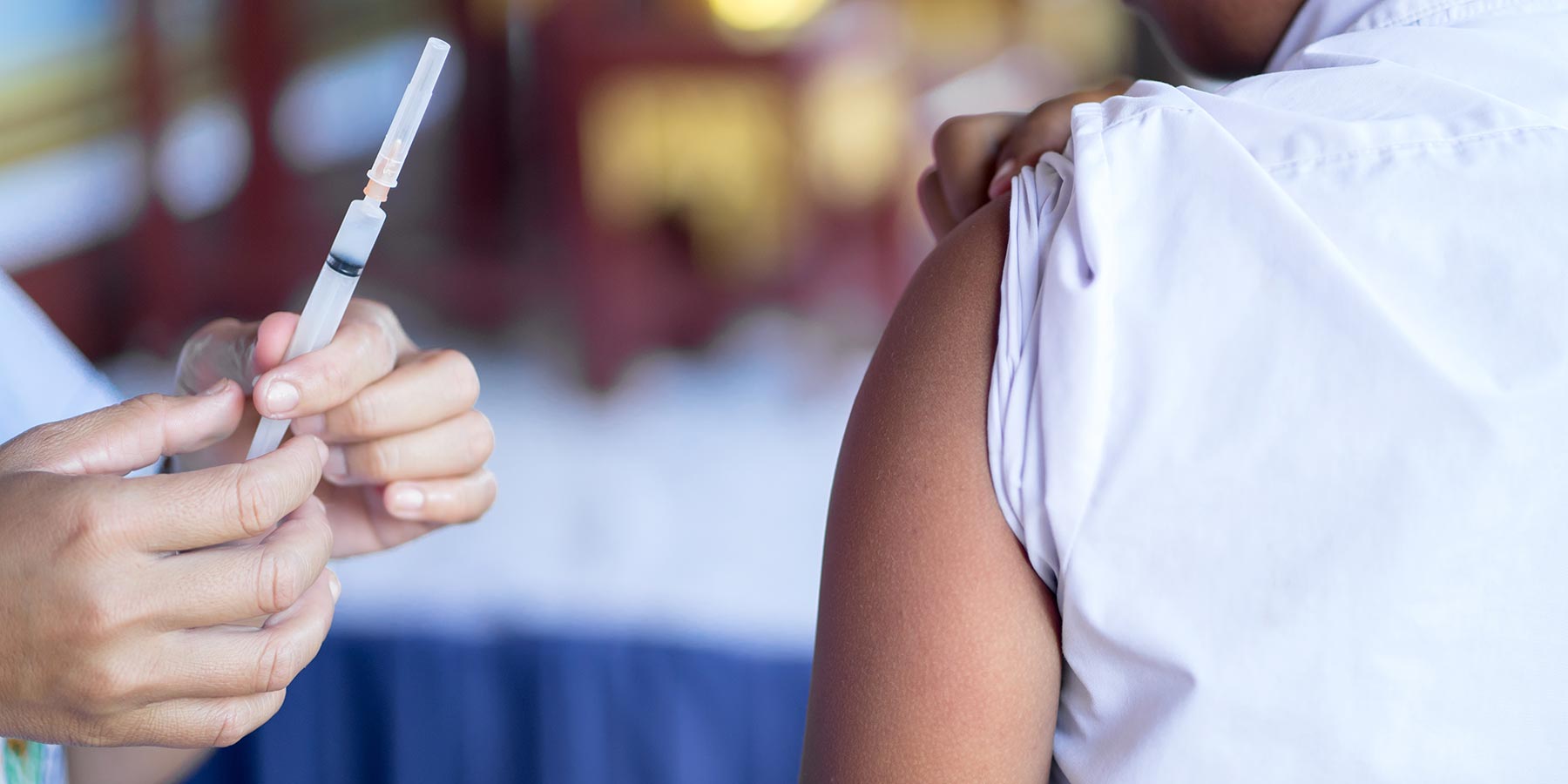 Photo of a person giving a flu shot to a young boy