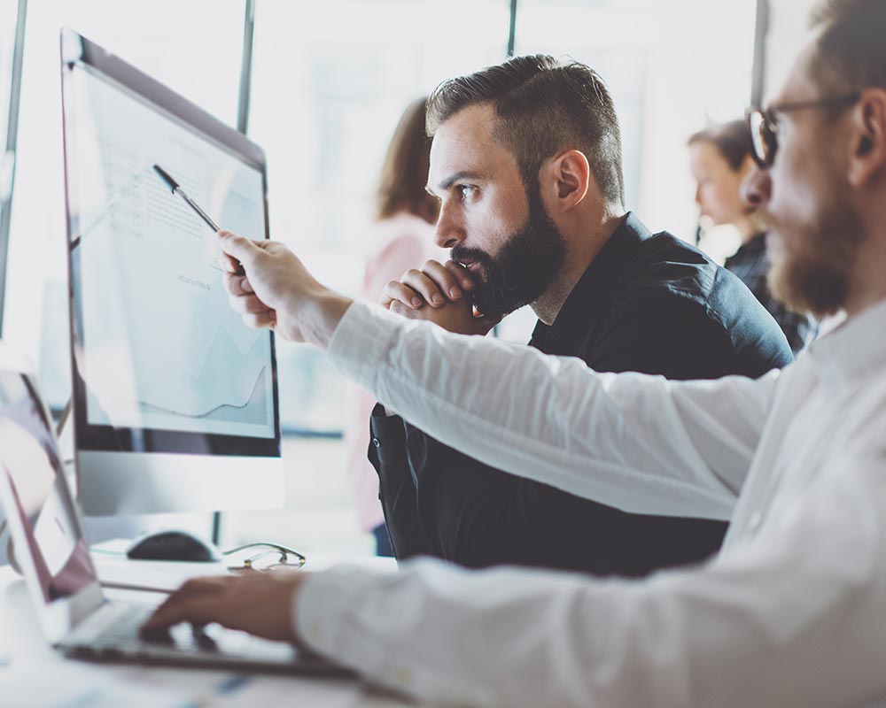 Coworkers pointing at things on computer