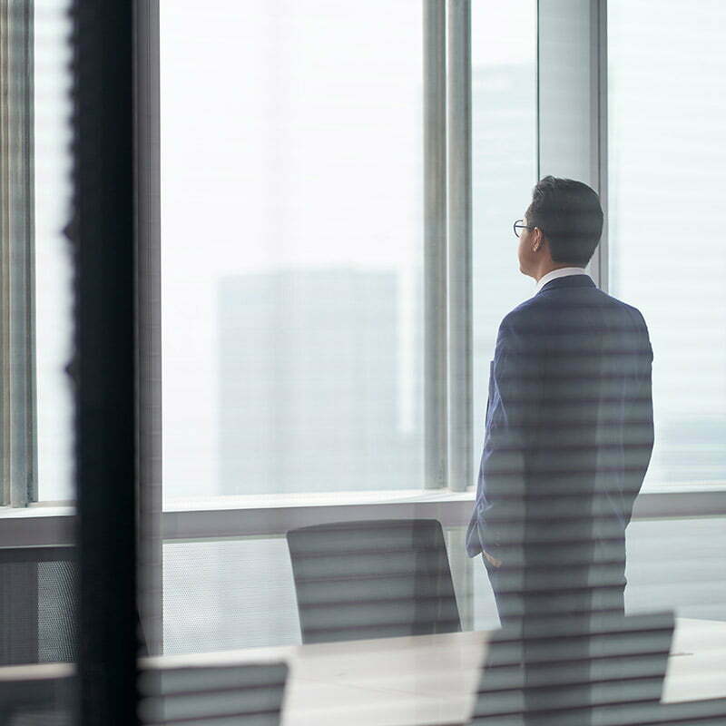 Business man in empty room looking out of the window