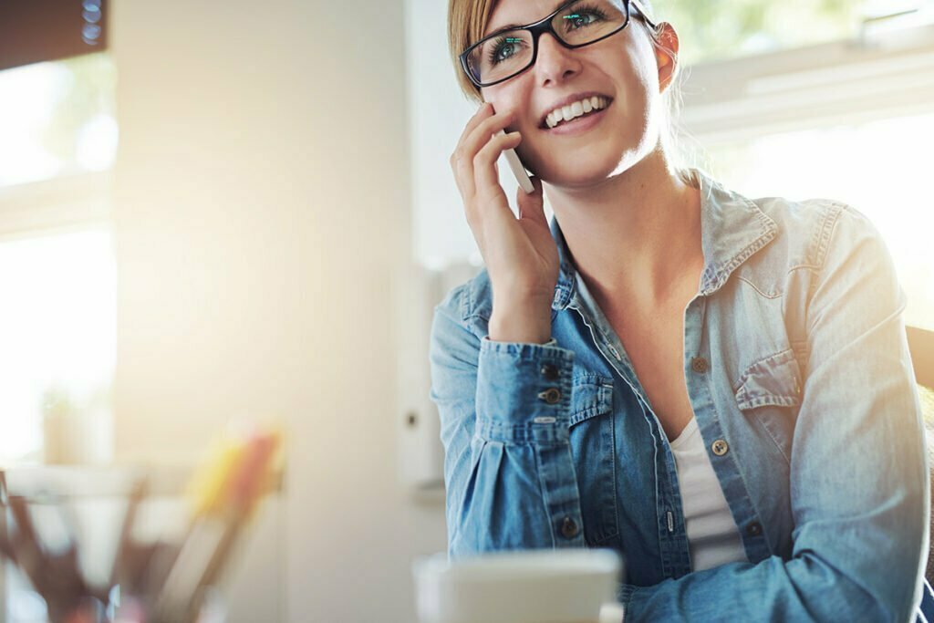 Happy lady in jean jacket taking a phone call