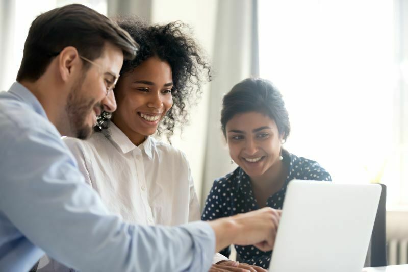 a group of people reviewing information on laptop